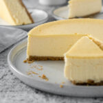 Sliced Philadelphia cheesecake on a serving plate.