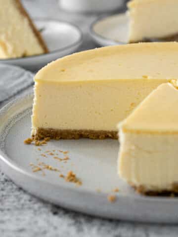 Sliced Philadelphia cheesecake on a serving plate.