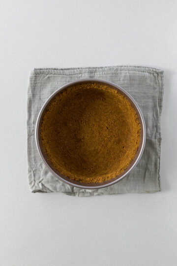 Step 5 - biscuit crumbs pressed into a loose-bottom cake pan.
