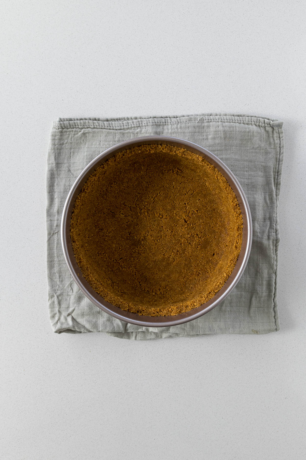 Step 5 - biscuit crumbs pressed into a loose-bottom cake pan.