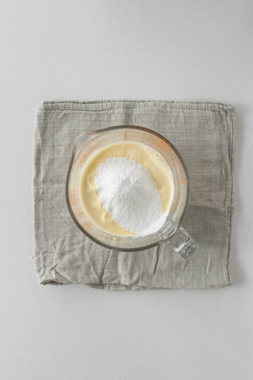Step 8 - icing sugar added to the cream to be whipped to stiff peaks.