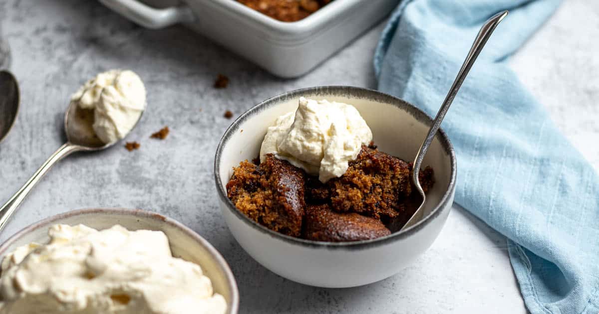 Tipsy tart dished up into a bowl with some whipped cream.
