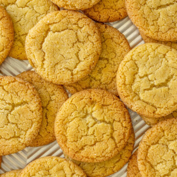 Vanilla sugar cookies strewn on a baking sheet.