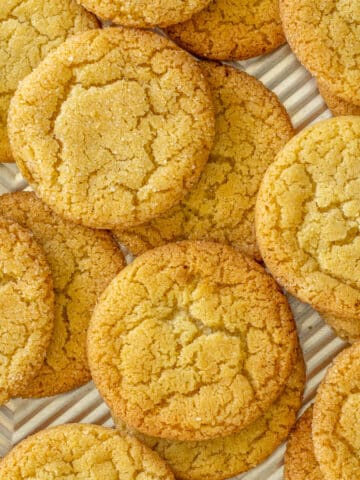 Vanilla sugar cookies strewn on a baking sheet.