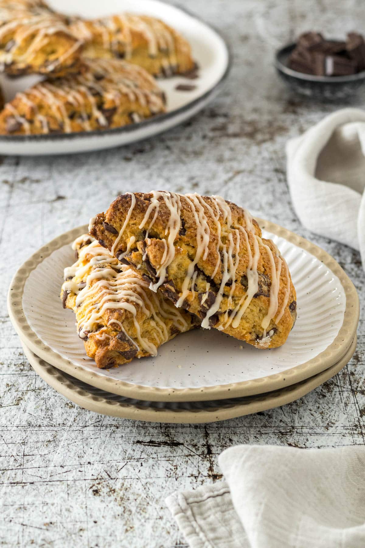 Two chocolate chip scones propped on each other on a plate.