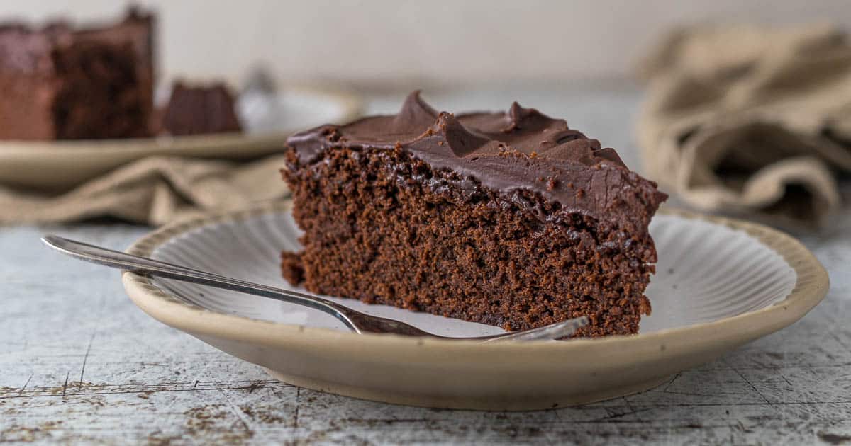 Sliced fudgy chocolate cake with chocolate ganache on a plate.