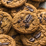 Chocolate chip espresso cookies on top of each other on a baking tray.