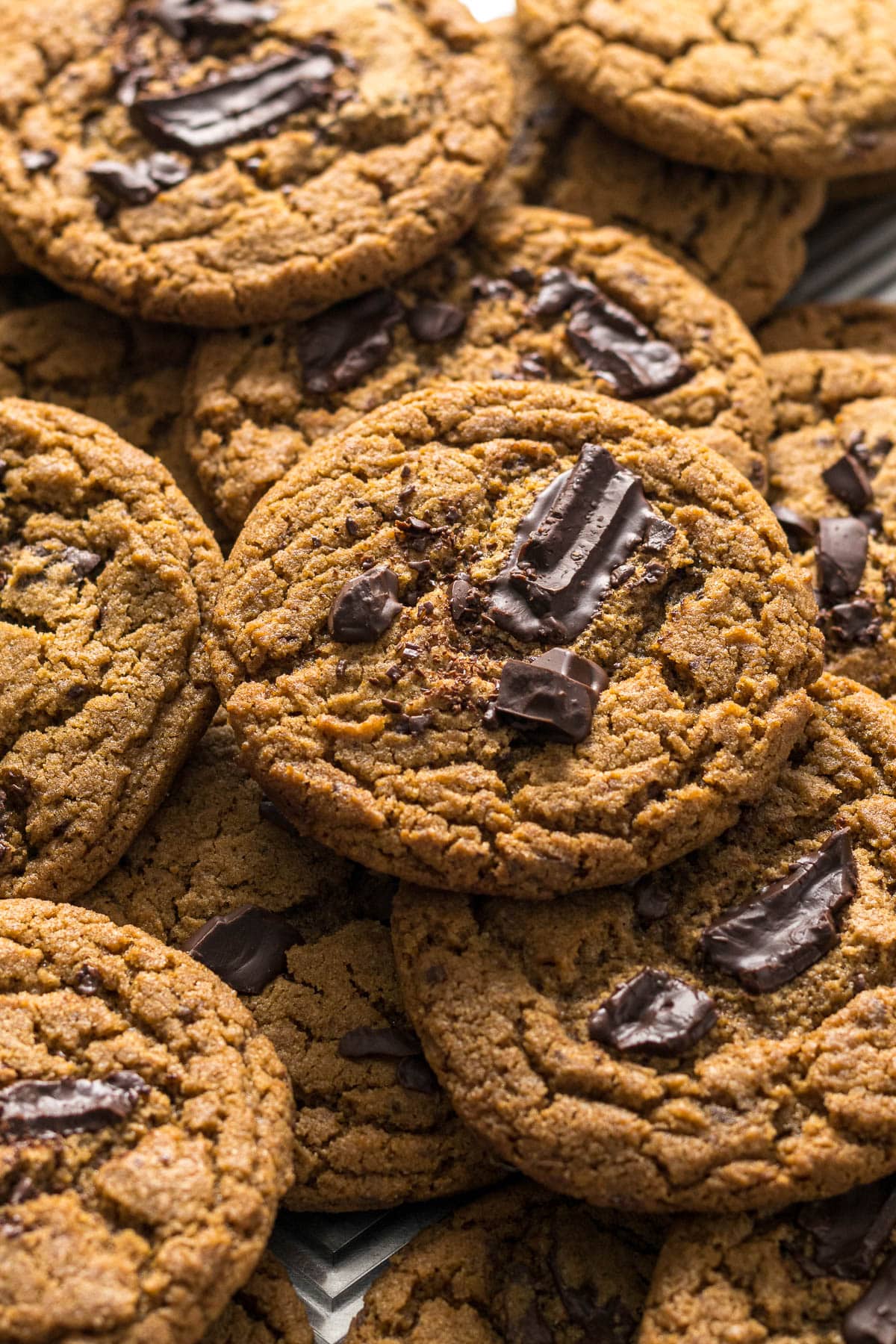 Chocolate chip espresso cookies on top of each other on a baking tray.