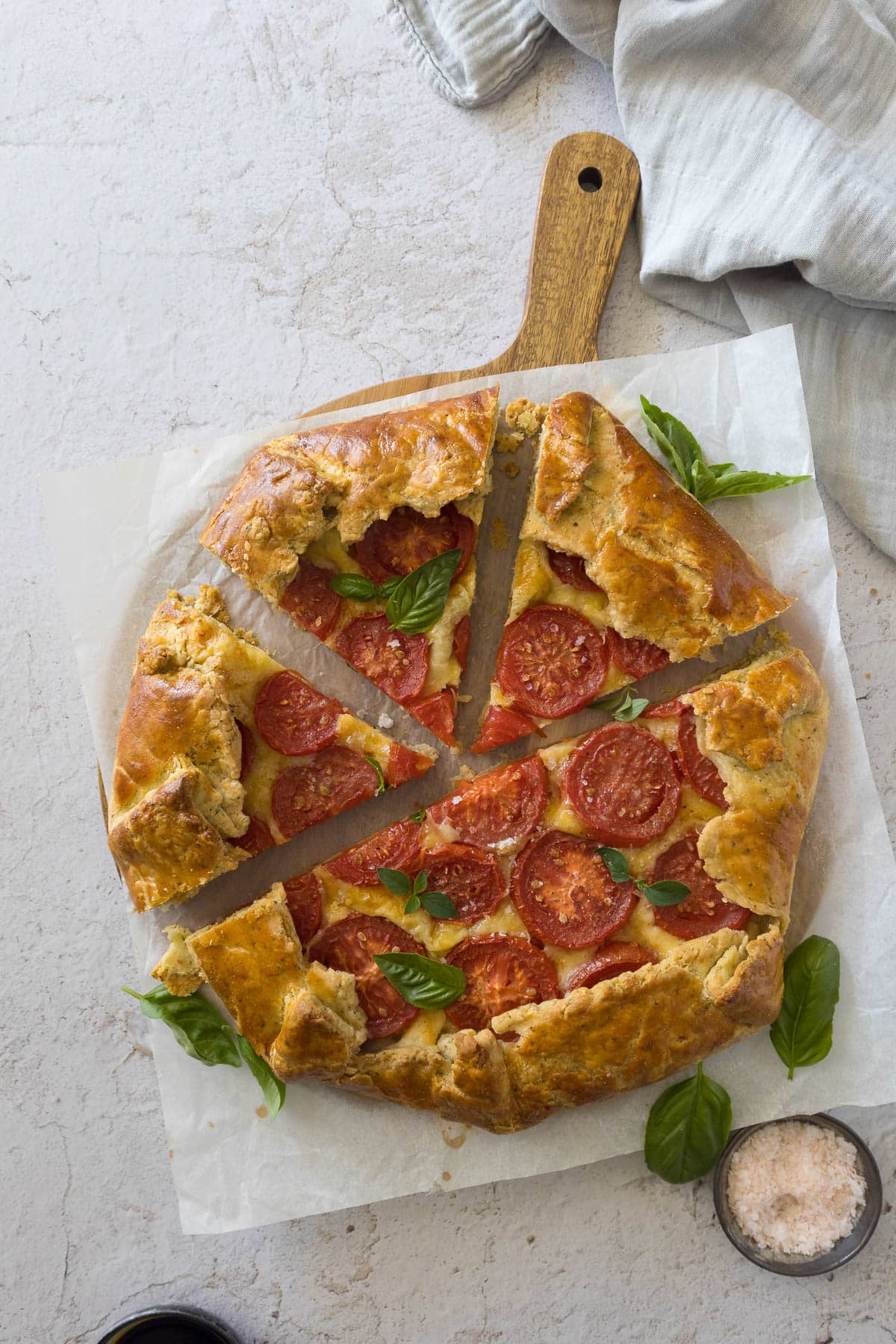 A sliced tomato galette on a serving board.