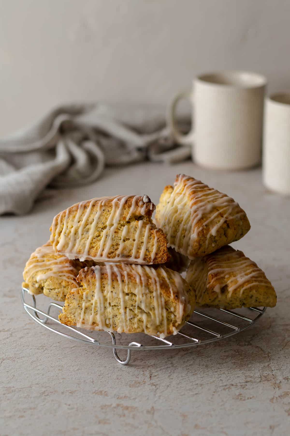 Lemon poppy seed scones piled on a cooling rack.