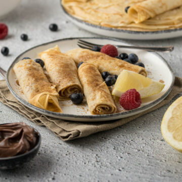 Pannekoek with cinnamon sugar on a plate.