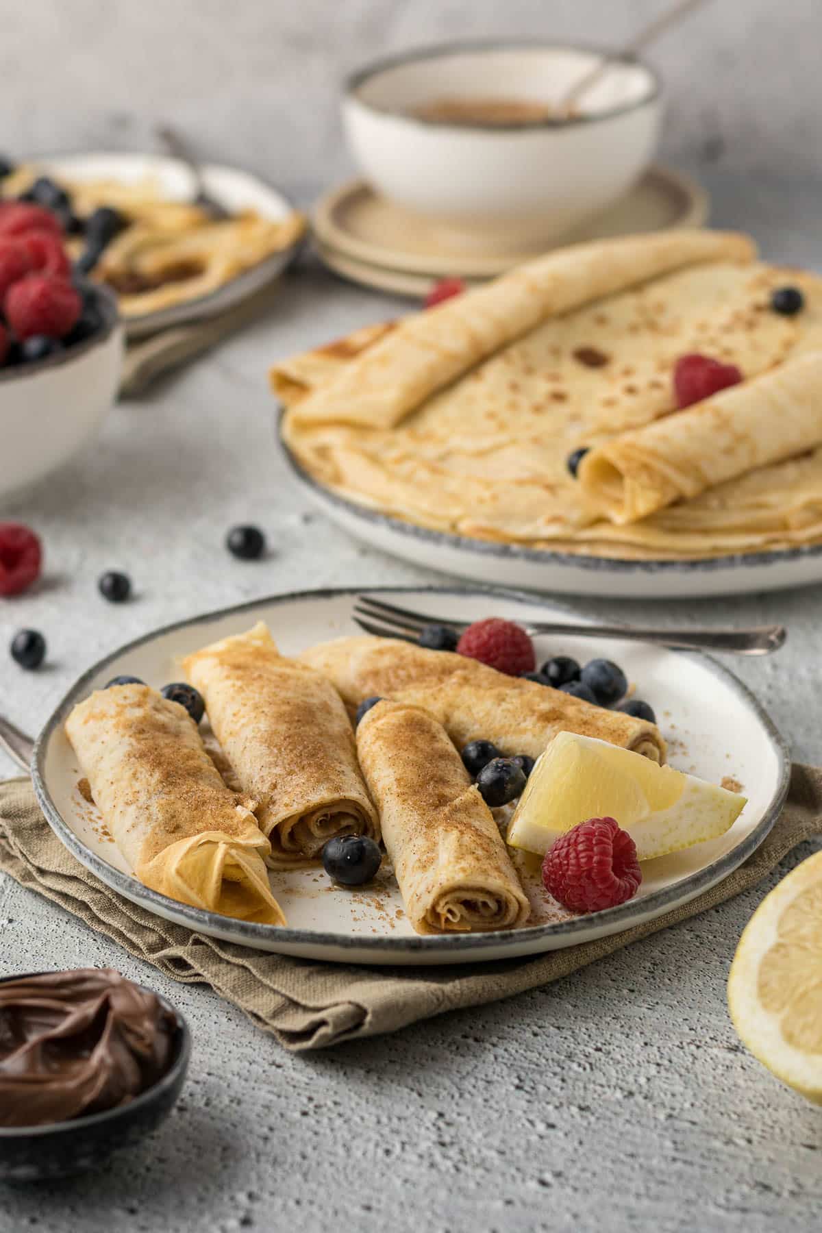 Pannenkoeken or pannekoek with cinnamon sugar and lemon on a plate.