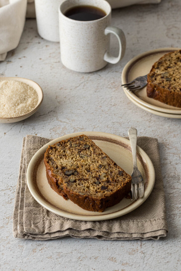 A slice of banana and date bread on a plate.