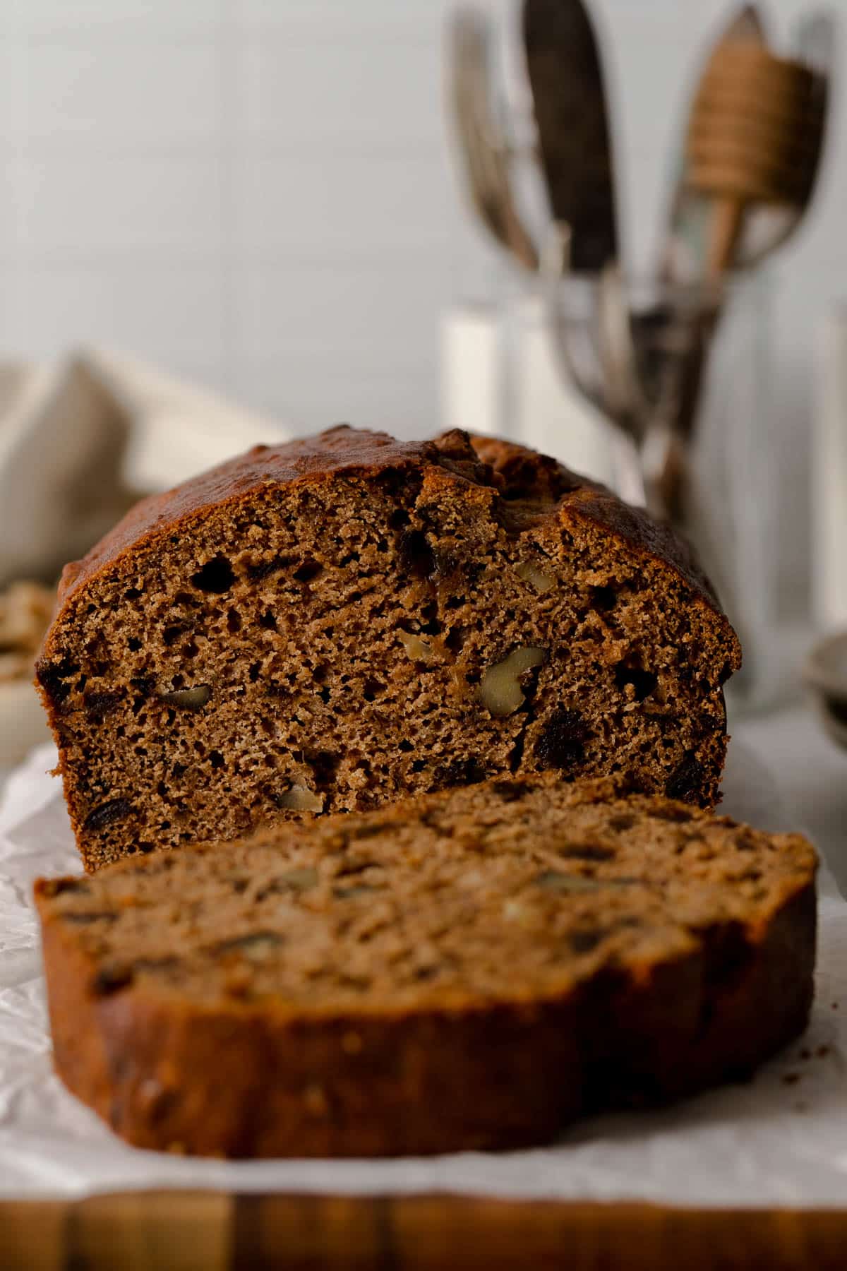 Sliced date walnut loaf cake on a board.