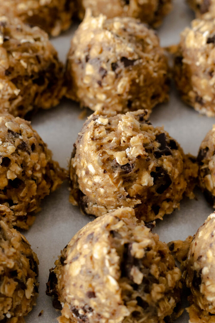 Oatmeal chocolate chip cookie dough balls on a baking tray.