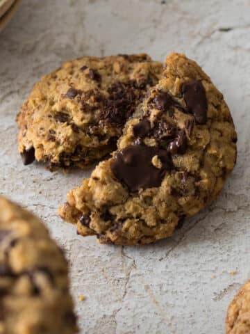 Oatmeal chocolate chip cookie broken in half.